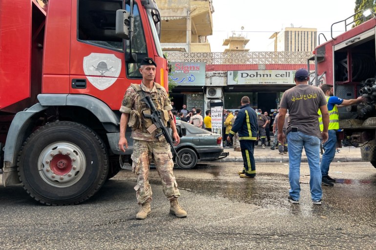 A Lebanese army soldier stands guard near fire trucks at the scene of a reported pager device explosion in Saida in southern Lebanon on September 18, 2024