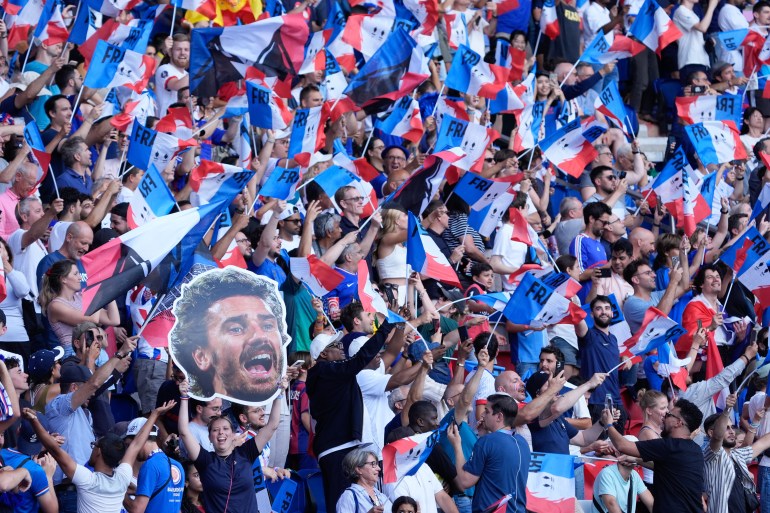 Aug 9, 2024; Paris, France; French fans wave flags and hold up a cutout of midfielder Antoine Griezmann before the men's soccer gold medal match against Spain during the Paris 2024 Olympic Summer Games at Parc des Princes. Mandatory Credit: Jack Gruber-USA TODAY Sports