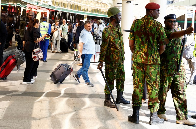 Riot police officers stand guard as passengers wait for their flights during a strike by Kenya airports union workers to protest against a proposed deal for India's Adani Group ADEL.NS, to lease Jomo Kenyatta International Airport (JKIA) for 30 years, in Nairobi, Kenya September 11, 2024. REUTERS/Thomas Mukoya