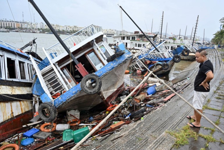 A man checks boats damaged after Super Typhoon Yagi hit Ha Long bay, in Quang Ninh province