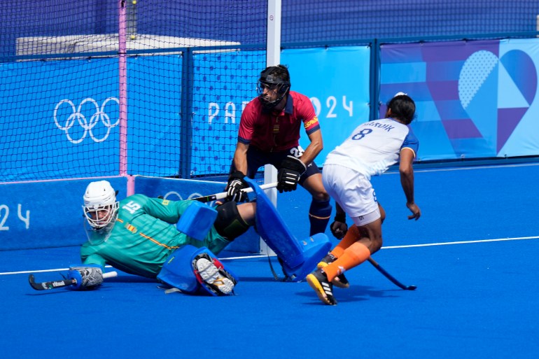 Spain's goalkeeper Luis Calzado, left, is unable to stop a shot on the goal by India's Harmanpreet Singh during the men's bronze medal field hockey match between India and Spain at the Yves-du-Manoir Stadium during the 2024 Summer Olympics, Thursday, Aug. 8, 2024, in Colombes, France. (AP Photo/Aijaz Rahi)