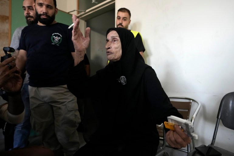 A woman, who fled the Israeli airstrikes in the south, reacts as she arrives at a school turned into a shelter in Beirut, Monday, Sept. 23, 2024. (AP Photo/Bilal Hussein)