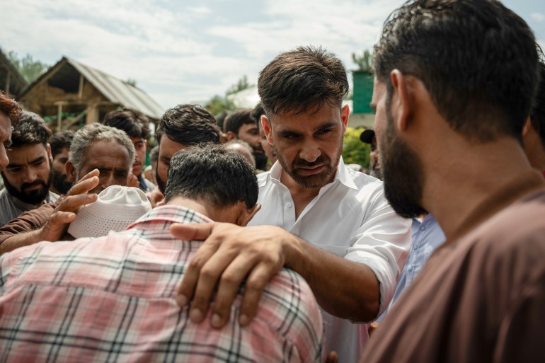 Waheed Para embraces an elderly, whose son has been detained under the Public Safety Act, promising him relief. (scene mentioned in the story) [Abrar Fayaz/Al Jazeera]