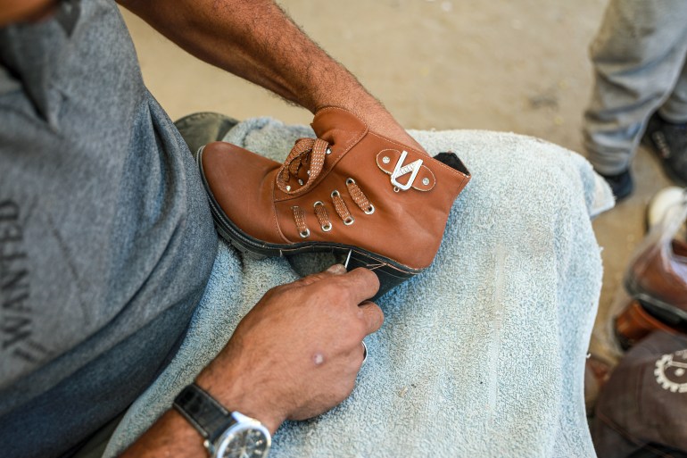 A cobbler's hands as he tried to mend a worn-out show as Israel's war on Gaza continues, depriving people from the ability to clothe themselves or their children