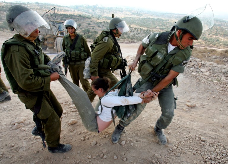 Israeli forces arrest a protester.