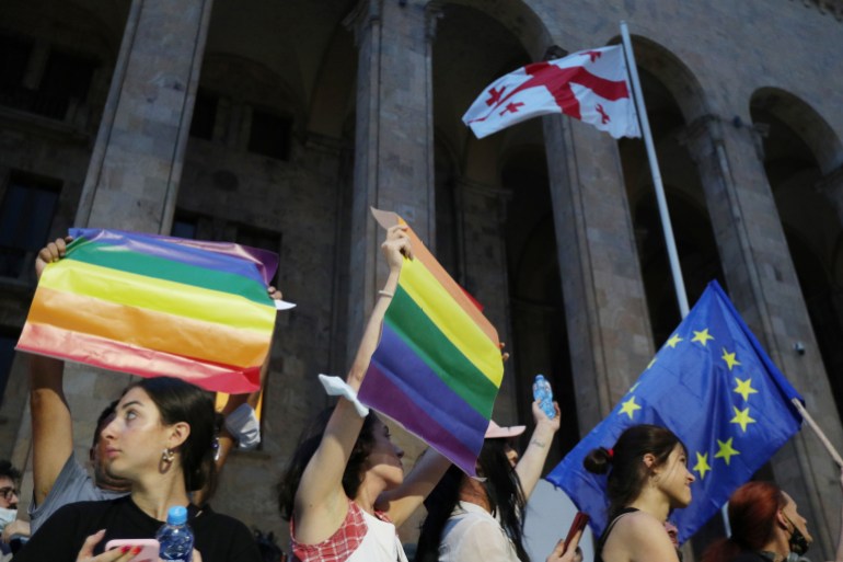 Participants hold flags during a rally in support of those who were injured during the July 5 protests, when a pride march was disrupted by members of violent groups