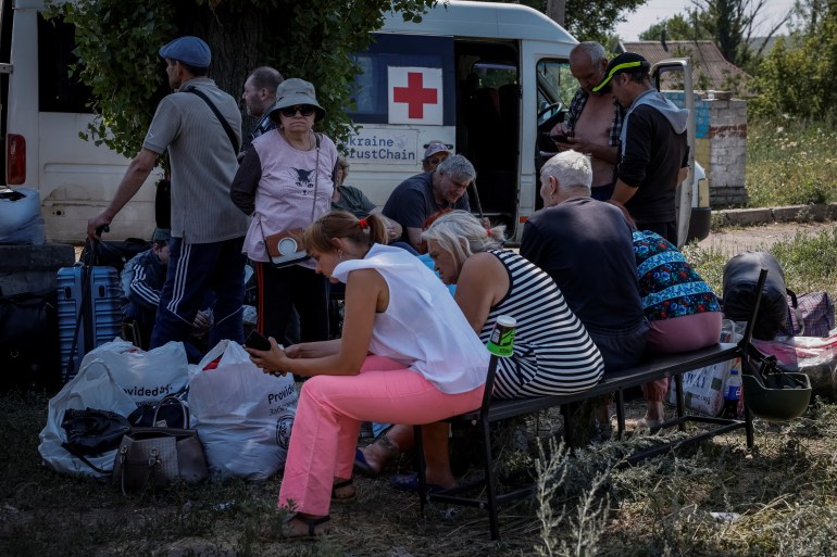 People, who were evacuated from the town of Toretsk, wait for a bus to continue their evacuation trip, amid Russia's attack on Ukraine, near Toretsk, in Donetsk region, Ukraine July 3, 2024