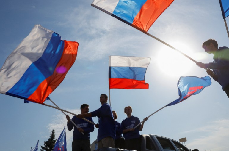 Activists wave flags during an event marking Russian President Vladimir Putin's 72nd birthday in the course of Russia-Ukraine conflict in Donetsk, Russian-controlled Ukraine, October 7, 2024. REUTERS/Alexander Ermochenko