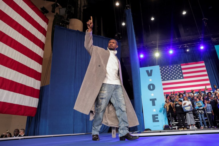 Usher walks across the stage in Atlanta to appear at a Kamala Harris rally.