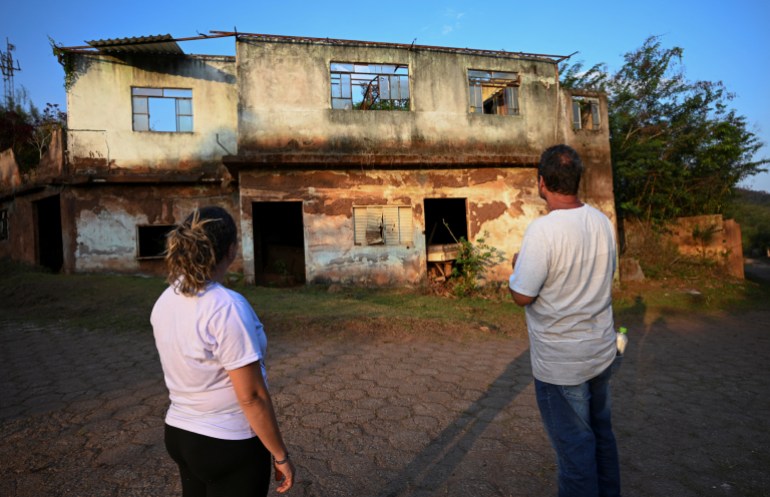 Residents of Bento Rodrigues district, which was covered with mud after a dam owned by Vale SA and BHP Billiton Ltd burst, look at the remains of a house in Mariana, Minas Gerais state, Brazil October 17, 2024. 