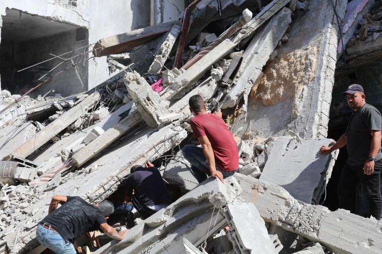 GAZA CITY, GAZA - OCTOBER 08: Civil defense teams and Palestinian residents conduct a search and rescue operation around the destruction following the Israeli attacks at Bureij refugee camp in Gaza City, Gaza on October 08