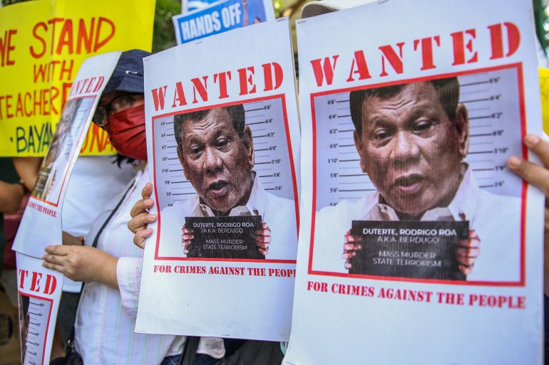 People holding up 'wanted posters' for Rodrigo Duterte in Manila