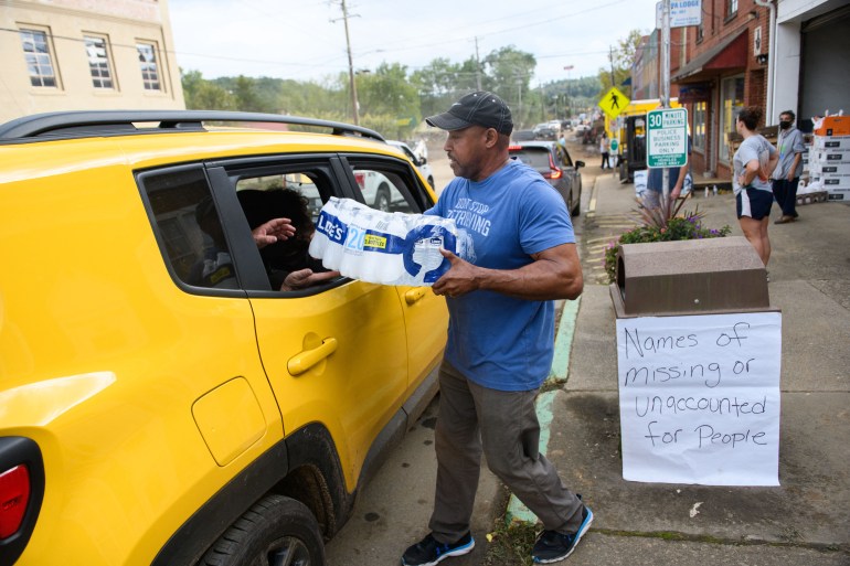 OLD FORT, NORTH CAROLINA - SEPTEMBER 30: Old Fort Resident Tony J. Daniel, hands out bottled water at the Town Hall on Catawba Avenue in the aftermath of Hurricane Helene on September 30, 2024 in Old Fort, North Carolina. At least 100 people have been killed across the southeastern U.S., according to published reports. Millions are without power due to the storm, which made landfall as a Category 4 hurricane on Thursday. The White House has approved disaster declarations in North Carolina, Florida, South Carolina, Tennessee, Georgia, Virginia and Alabama, freeing up federal emergency management money and resources for those states. Melissa Sue Gerrits/Getty Images/AFP (Photo by Melissa Sue Gerrits / GETTY IMAGES NORTH AMERICA / Getty Images via AFP)