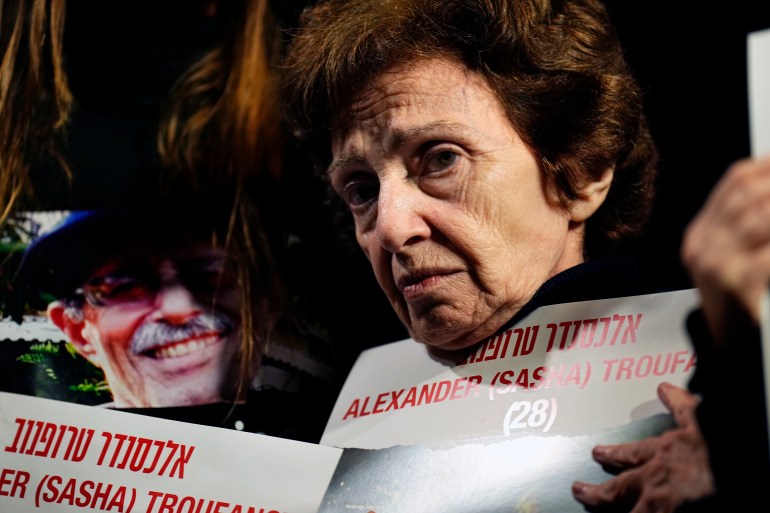 a woman wearing black holds a sign