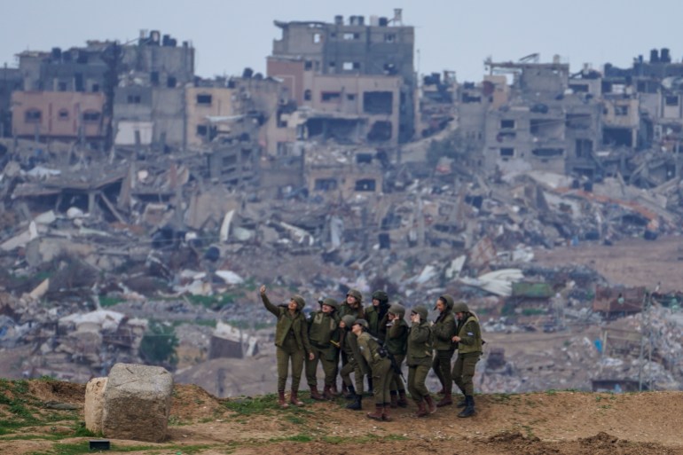 Israeli female soldiers pose for a photo on a position on the Gaza Strip border