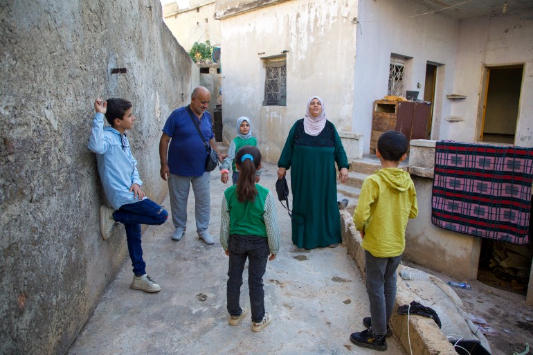 Musa Baghdadi and Warda Yunis with their four grandchildren, having finally reached their old home in Al-Bara town, Idlib [Ali Haj Suleiman/Al Jazeera]