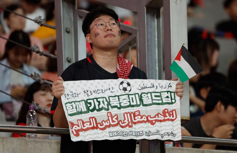 Soccer Football - World Cup - AFC Qualifiers - Group B - South Korea v Palestine - Seoul World Cup Stadium, Seoul, South Korea - September 5, 2024 A fan holds a banner that reads "South Korea and Palestine let's go to world cup together" during the match REUTERS/Kim Soo-Hyeon