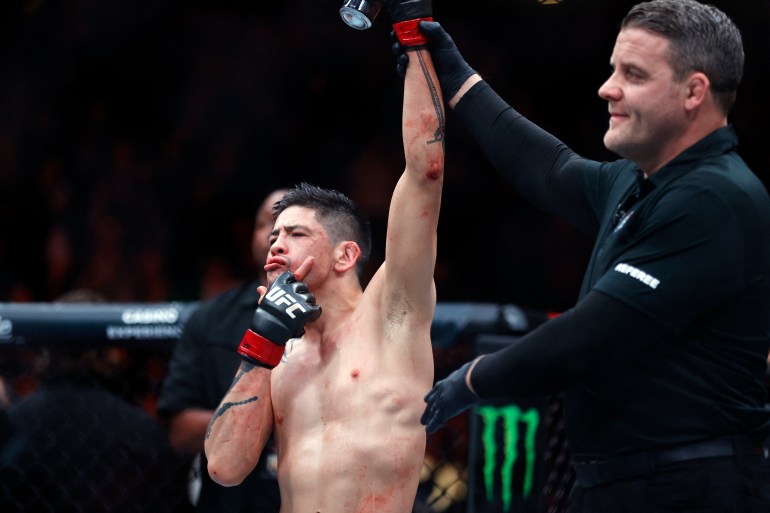 Nov 2, 2024; Edmonton, Alberta, Canada; Brandon Moreno (red gloves) celebrates after defeating Amir Albazi (not pictured) in a flyweight bout during UFC Fight Night at Rogers Place. Mandatory Credit: Perry Nelson-Imagn Images