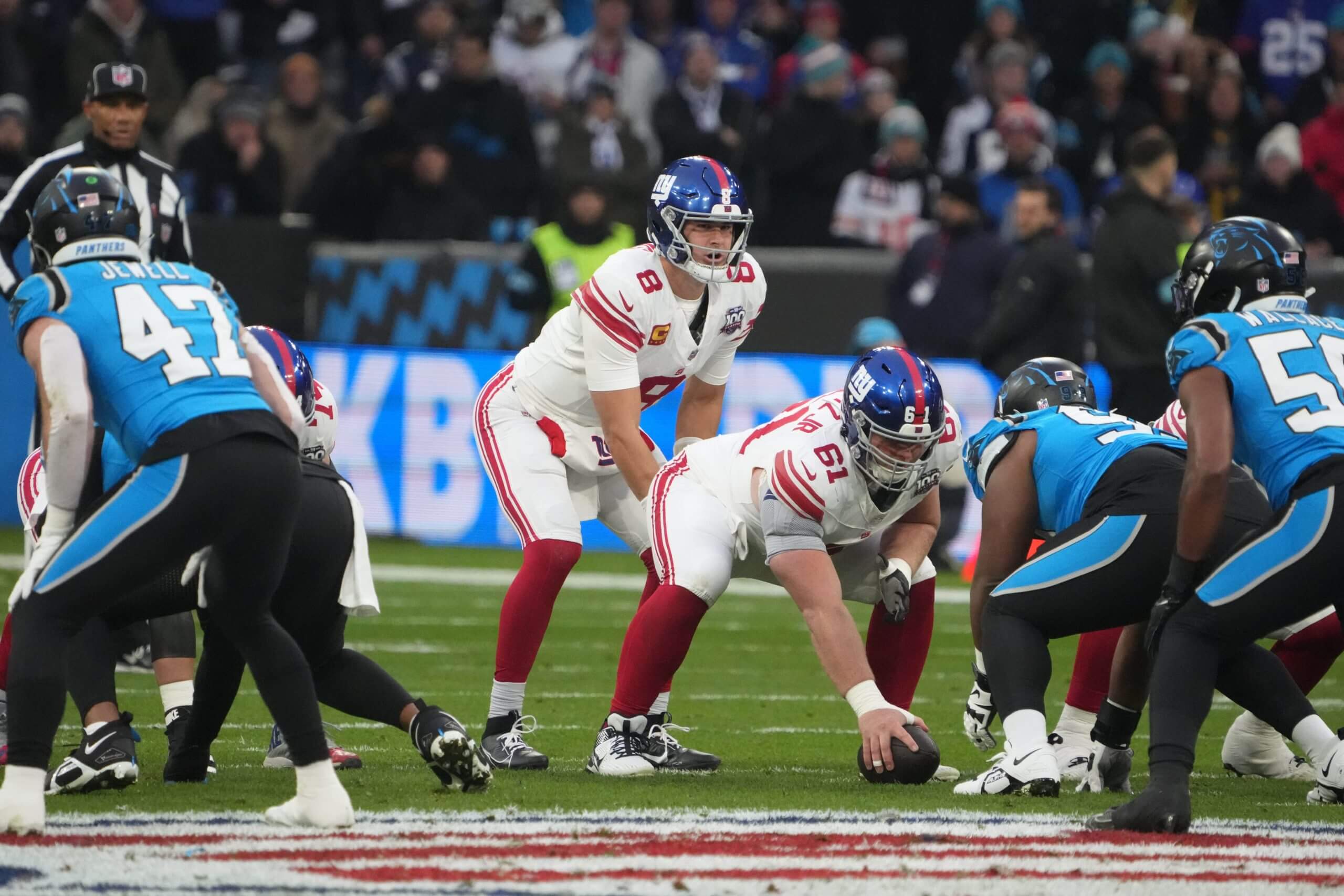 New York Giants quarterback Daniel Jones takes the snap from center John Michael Schmitz Jr. in the first half during the 2024 NFL Munich Game at Allianz Arena.