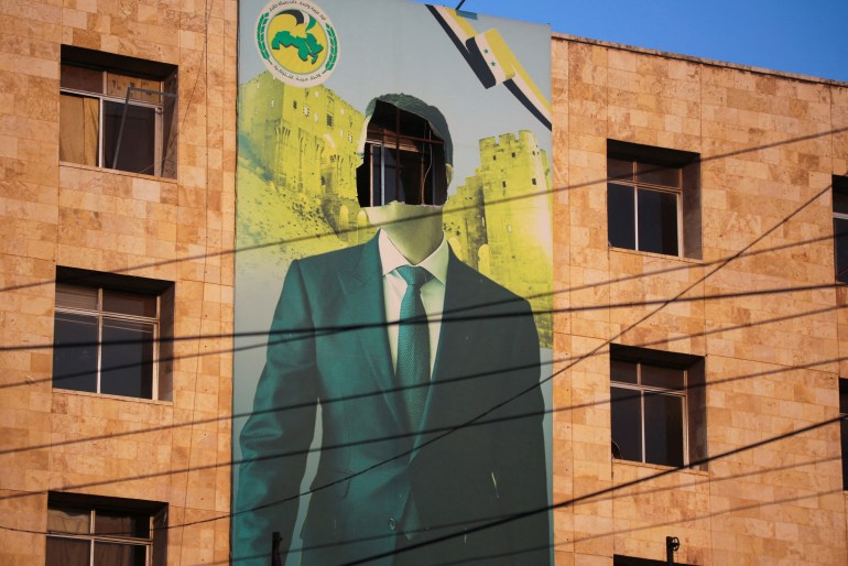 A damaged building-sized mural of President Bashar al-Assad.