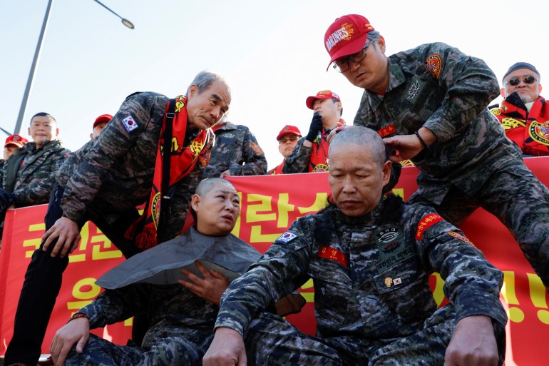 A South Korean marine veteran gets his head shaved during a rally demanding South Korean President Yoon Suk Yeol's removal from power, in front of the presidential office, in Seoul, South Korea, December 5, 2024. REUTERS/Kim Soo-hyeon