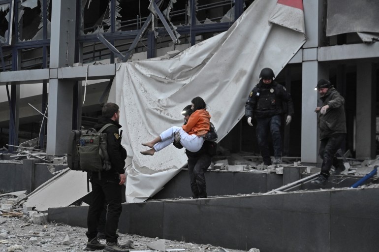 A police officer evacuates a woman from a building heavily damaged by a Russian missile strike, amid Russia's attack on Ukraine, in Zaporizhzhia, Ukraine December 10, 2024. REUTERS/Stringer