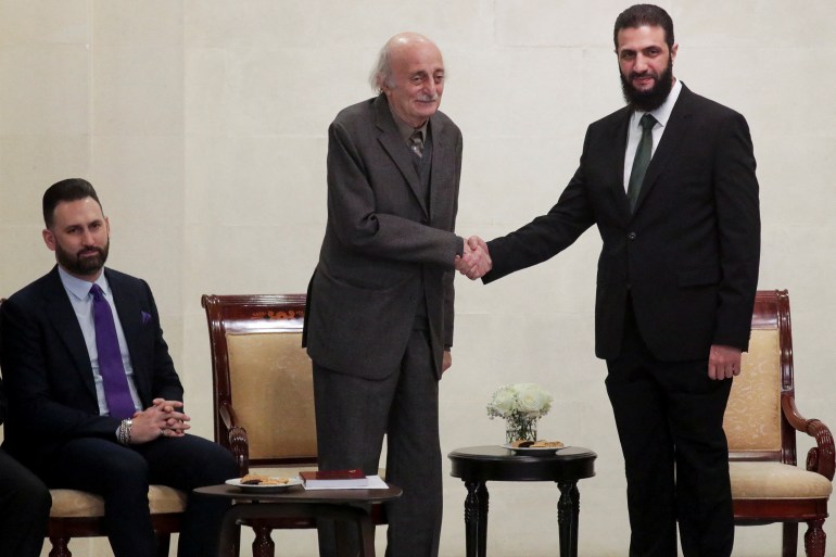 Lebanese Druze leader Walid Jumblatt shakes hands with Syria's de facto leader Ahmed al-Sharaa, also known as Abu Mohammed al-Golani, next to Jumblatt's son Taymur, after the ousting of Syria's Bashar al-Assad, in Damascus, Syria