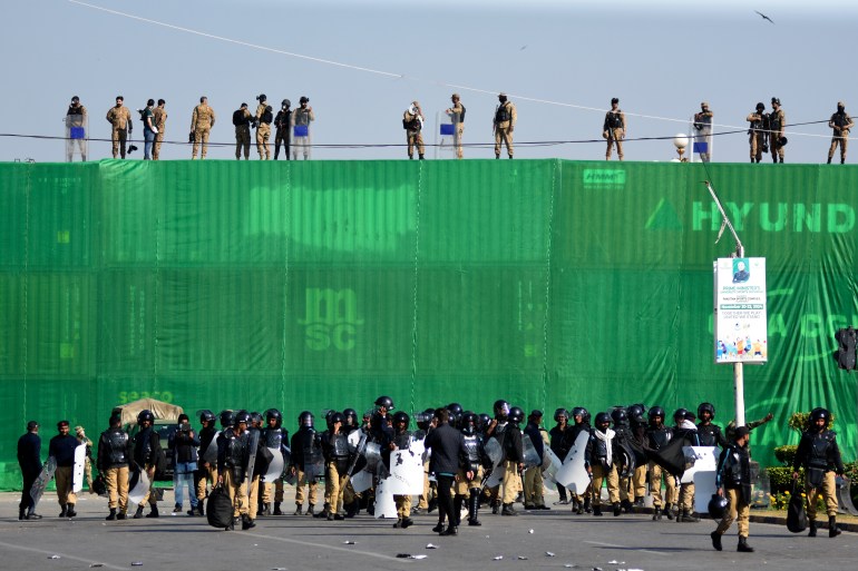 Pakistan's army troops and police officers take positions at D-Chowk square close to Red Zone, which is an area that houses key government buildings, ahead of a protest by supporters of imprisoned former premier Imran Khan's Pakistan Tehreek-e-Insaf party, in Islamabad, Pakistan, Tuesday, Nov. 26, 2024. (AP Photo/W.K. Yousufzai)