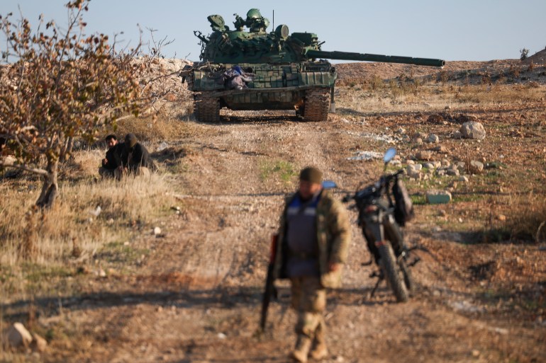 An abandoned Syrian army armoured vehicle sits on a field controlled by Syrian insurgents in the outskirts of Hama, Syria