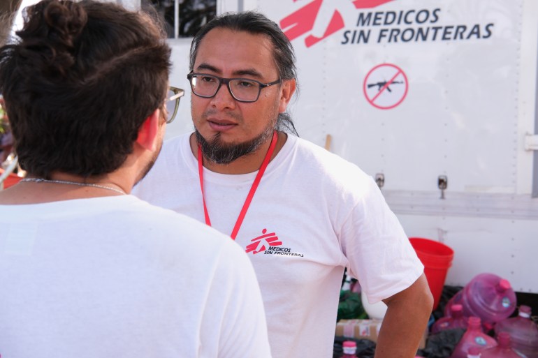 Ricardo Santiago of Doctors without Borders, standing in front of his nonprofit's vehicle