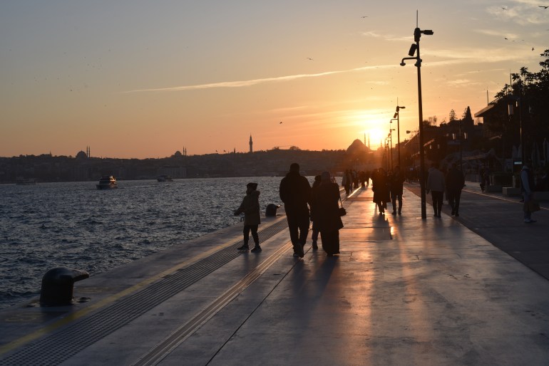 Families taking a walk at sunset in Galata Port, Istanbul, Turkey on November 29, 2024 [Simon Speakman Cordall/Al Jazeera]