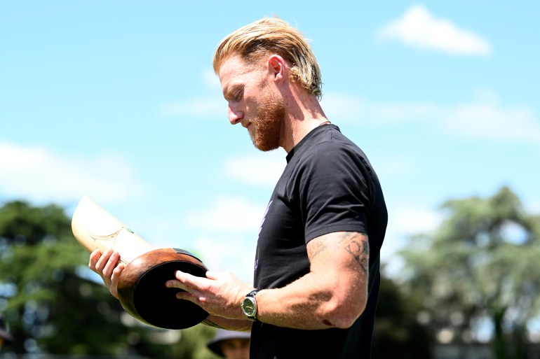 HAMILTON, NEW ZEALAND - DECEMBER 17: Ben Stokes of England inspects the Crowe-Thorpe Trophy at the end of day four of the Third Test Match in the series between New Zealand and England at Seddon Park on December 17, 2024 in Hamilton, New Zealand. (Photo by Hannah Peters/Getty Images)