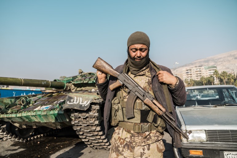 A gunman in Umayyad Square in Damascus celebrates the fall of Assad [Raghed Waked / Al Jazeera]